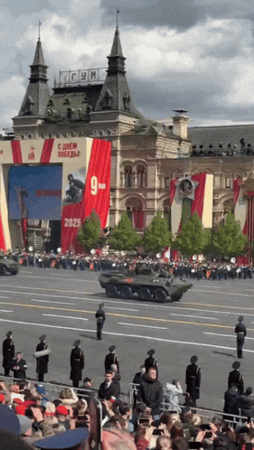a crowd of people watching a military parade in front of a building that says gym on it