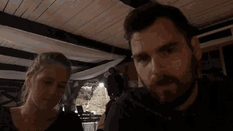 a man and a woman are sitting next to each other in a dark room .