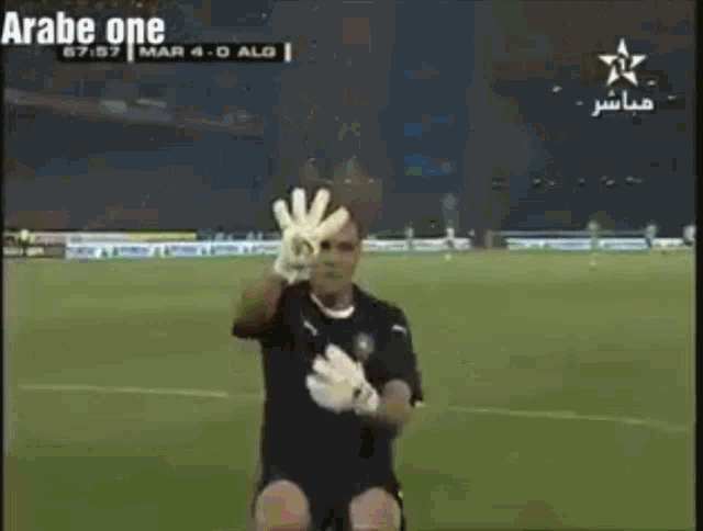 a soccer player wearing gloves is kneeling down and giving the number 4