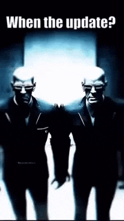 two men in suits are standing next to each other in a dark room with the words `` when the update ? '' above them .