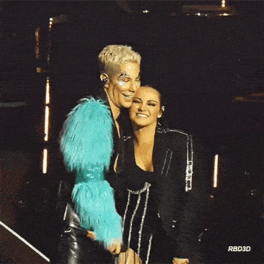 a man in a blue fur coat is standing next to a woman in a black dress ..