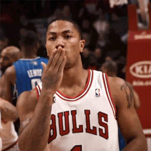 a basketball player wearing a bulls jersey blowing a kiss