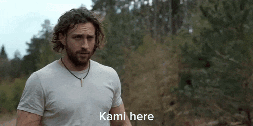 a man in a white shirt is standing in the woods with the words kami here below him