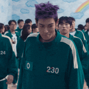 a man with purple hair wears a green jacket with the number 230 on it