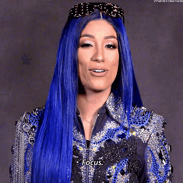a woman with long blue hair is wearing sunglasses and a jacket that says focus