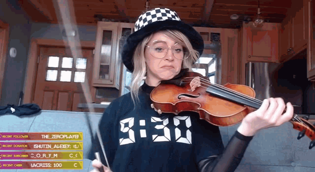 a woman is playing a violin in front of a screen that says 3:30 on it