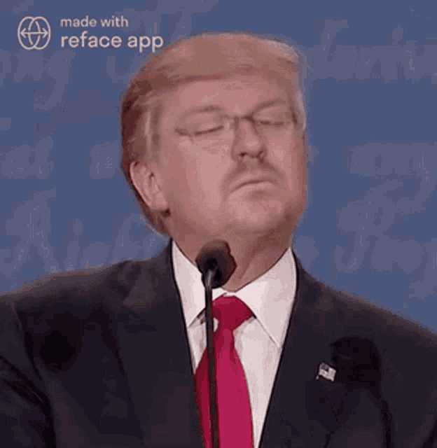donald trump is wearing glasses and a red tie while giving a speech .