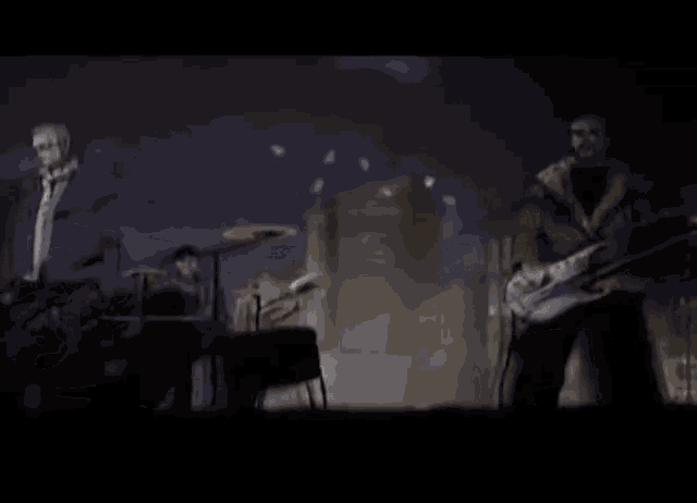 a man playing a guitar and another man playing drums on a stage