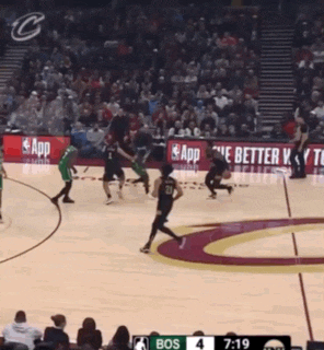 a basketball game is being played in front of a crowd with ads for app