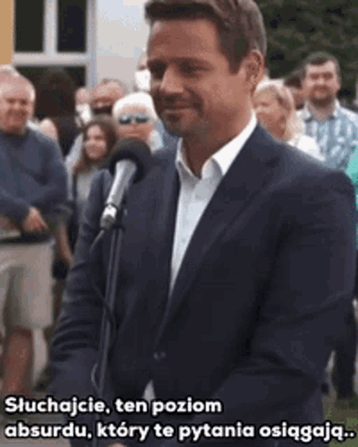 a man in a suit speaking into a microphone