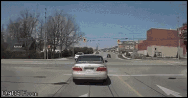 a car is driving through an intersection with the website datgif.com visible