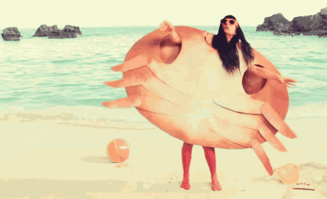 a woman in a crab costume stands on the beach