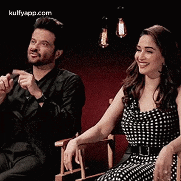 a man and a woman are sitting next to each other and smiling .