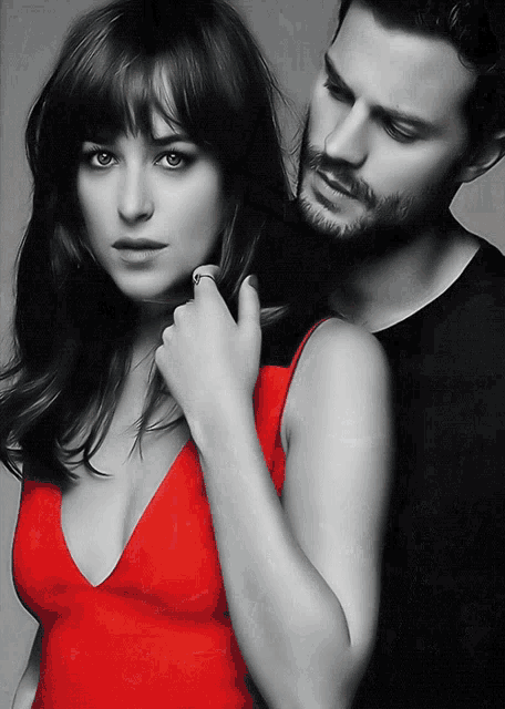 a woman in a red dress is standing next to a man