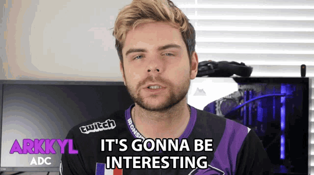 a man with a beard and a purple shirt that says arkkyl adc