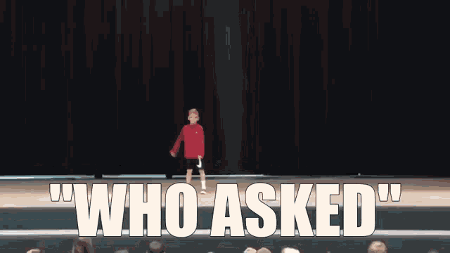 a young boy is standing on a stage with the words who asked behind him