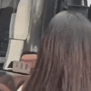 a woman with long hair is sitting in the back seat of a bus .