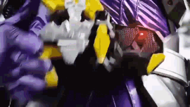 a close up of a purple and yellow robot with a red light coming out of it 's chest .