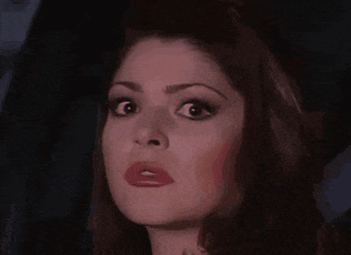a close up of a woman 's face with a surprised expression on her face .