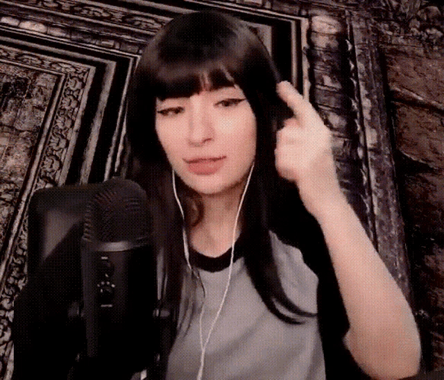 a woman wearing ear buds is giving the middle finger