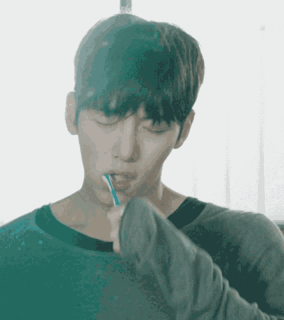 a young man is brushing his teeth with a toothbrush