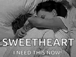 a man and a woman are hugging in bed .