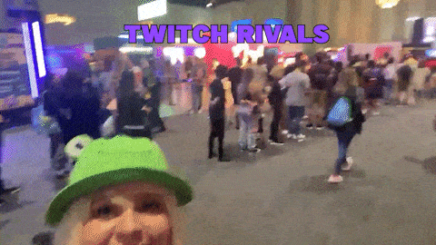 a woman wearing a green hat stands in front of a crowd with the words twitch rivals written above her