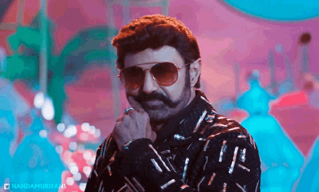 a man wearing sunglasses and a mustache is standing in front of a purple background