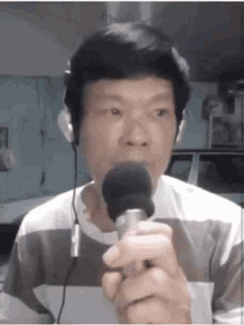 a man wearing headphones is holding a microphone