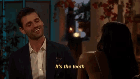 a man in a suit is smiling while talking to a woman in a dress .