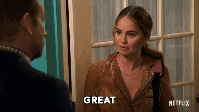 a woman in a brown shirt says great in front of a man