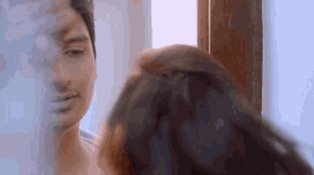 a man and woman are looking at each other in a mirror