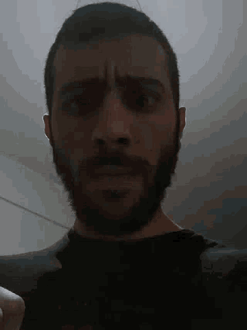 a close up of a man 's face with a beard .