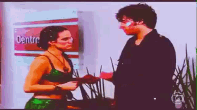a man and woman are standing next to each other in front of a sign that says centro