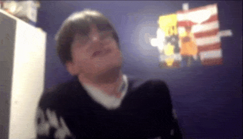 a blurry picture of a man in a room with a poster on the wall that says ' u.s.a. '