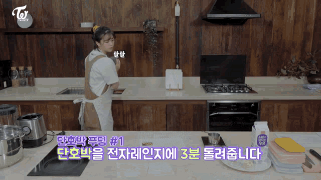 a woman in an apron is cooking in a kitchen with a twice logo on the wall
