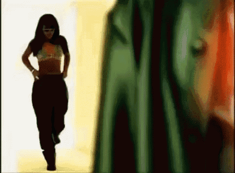 a woman in a bikini top and black pants is walking in a room .