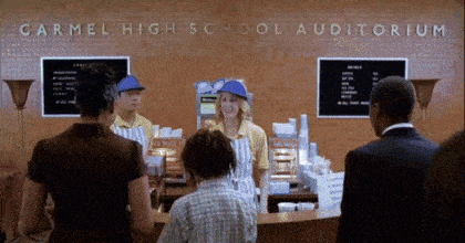 a group of people standing in front of a sign that reads carmel high school auditorium