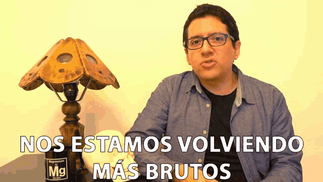 a man sitting in front of a lamp with the words nos estamos volviendo mas brutos on the bottom