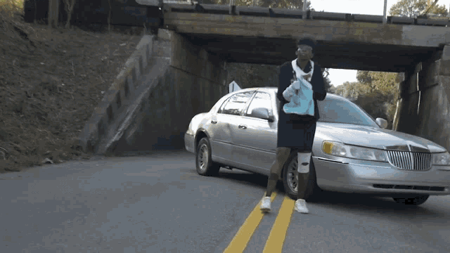 a person standing next to a lincoln limousine
