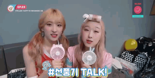 two girls are holding a fan and a sign that says # talk