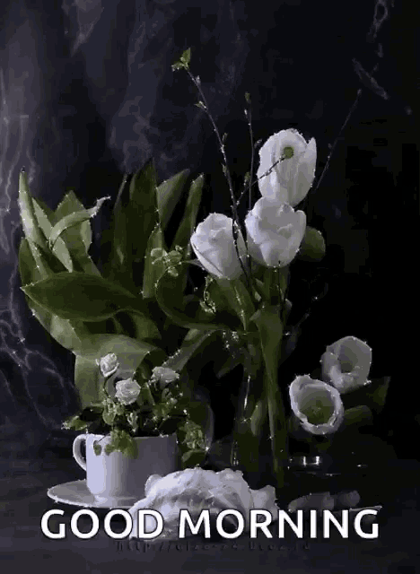 a bouquet of white flowers in a vase next to a cup of coffee and the words " good morning "