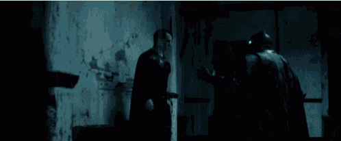 a person is standing in a dark room holding a knife .