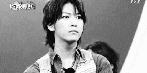 a black and white photo of a young man wearing a denim shirt .