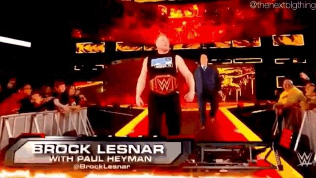 a man with a wrestling belt is walking on a stage with a name tag that says brock lesnar with paul heyman .