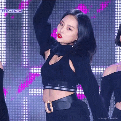 a woman in a black crop top stands in front of a screen with the words special stage on it