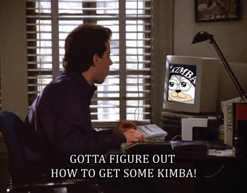 a man sits at a desk with a computer screen that says kimba on it