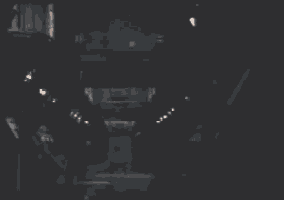 a blurry picture of a man in a black suit standing in a dark room