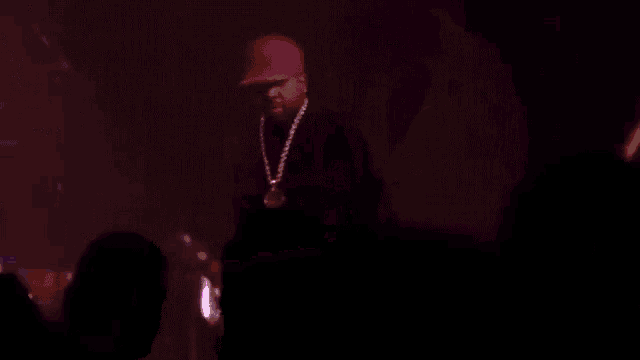 a man singing into a microphone on a stage with purple lights