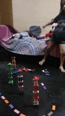 a girl is playing with dominoes on the floor
